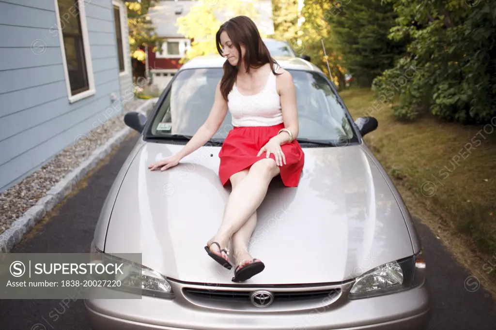 Woman Sitting on Car Hood