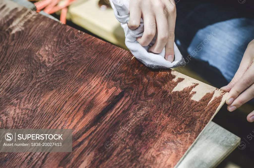 Young Woman's Hand Staining Wood Board