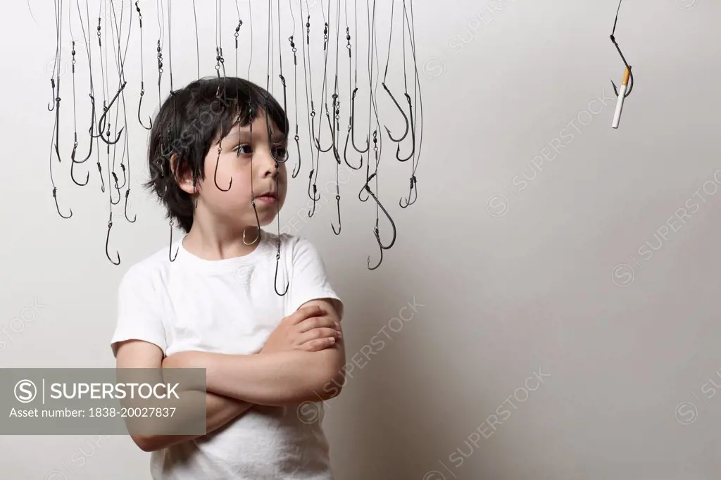 Boy Surrounded by Hanging Fish Hooks Looking at Cigarette on Fish Hook