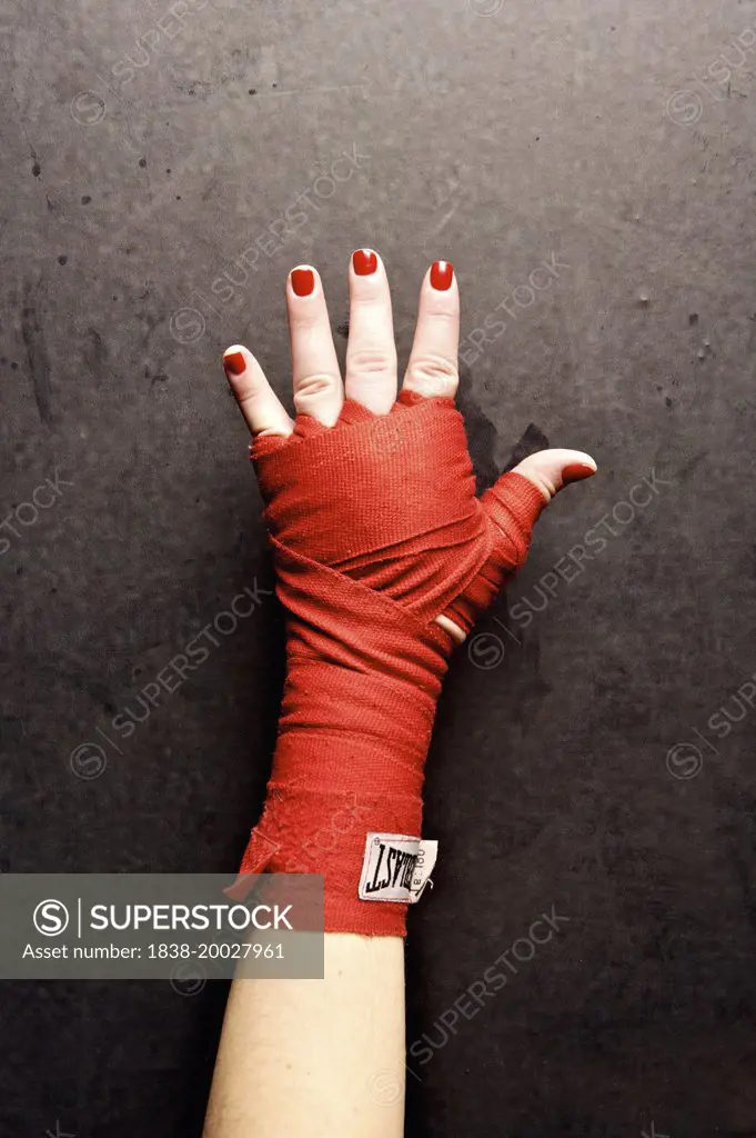 Female Boxer's Hand Wrapped in Red Tape