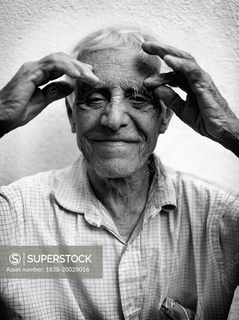 Elderly Man with Hands on Forehead