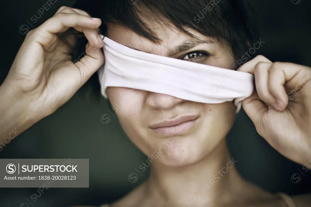 Woman Pulling Blindfold from Eyes