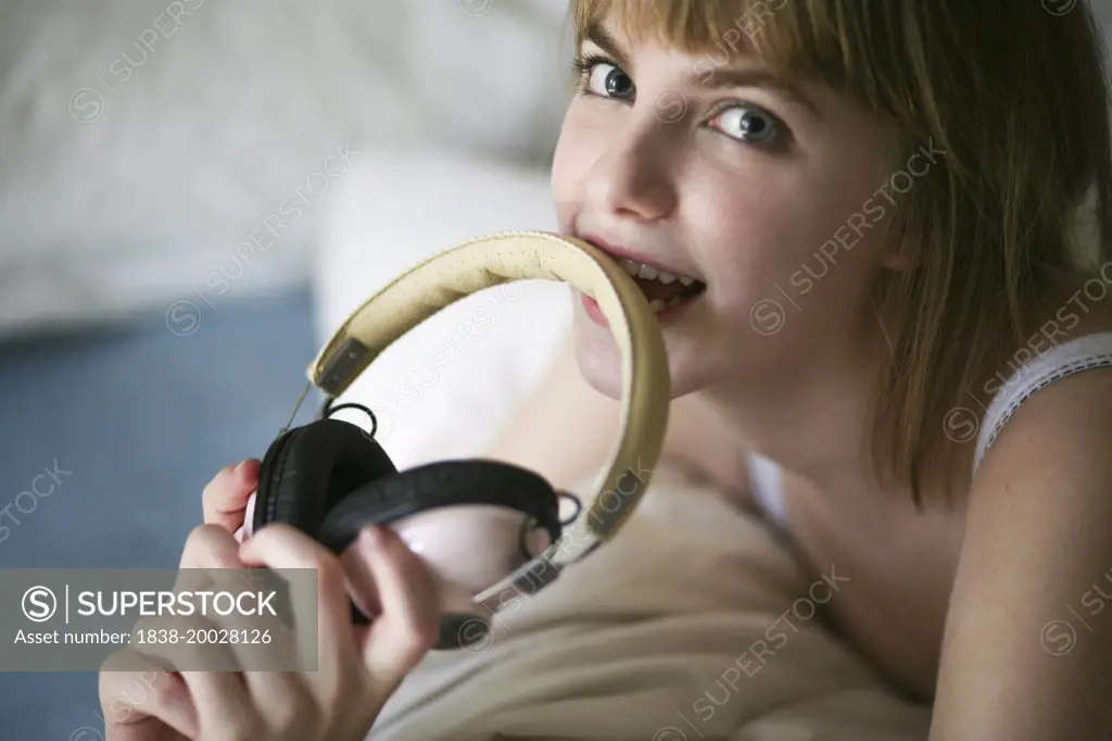 Young Woman Biting Headphones,