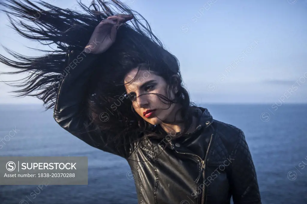 Woman Shaking Long Hair with Sea in Background