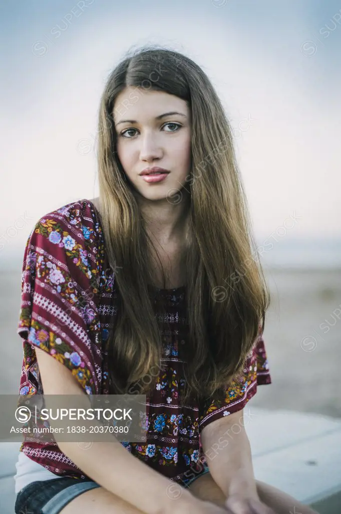 Portrait of Serious Teen Girl Sitting on Table at Beach
