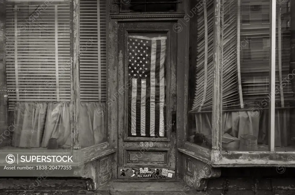 Shabby Storefront with American Flag Hanging in Door Window, Brooklyn, NYC, USA