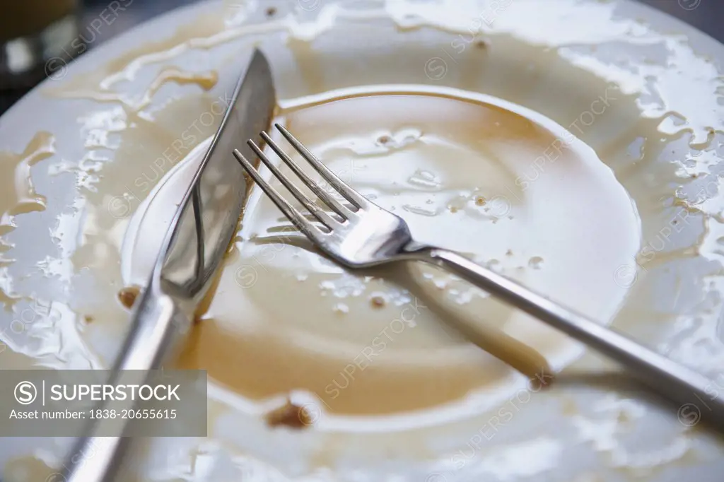Fork and Knife on Empty Plate with Syrup