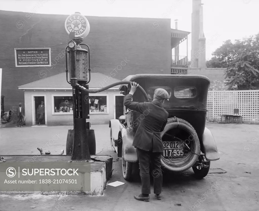 Man Putting Gas in Car at Gas Station, Washington DC, USA, circa 1920