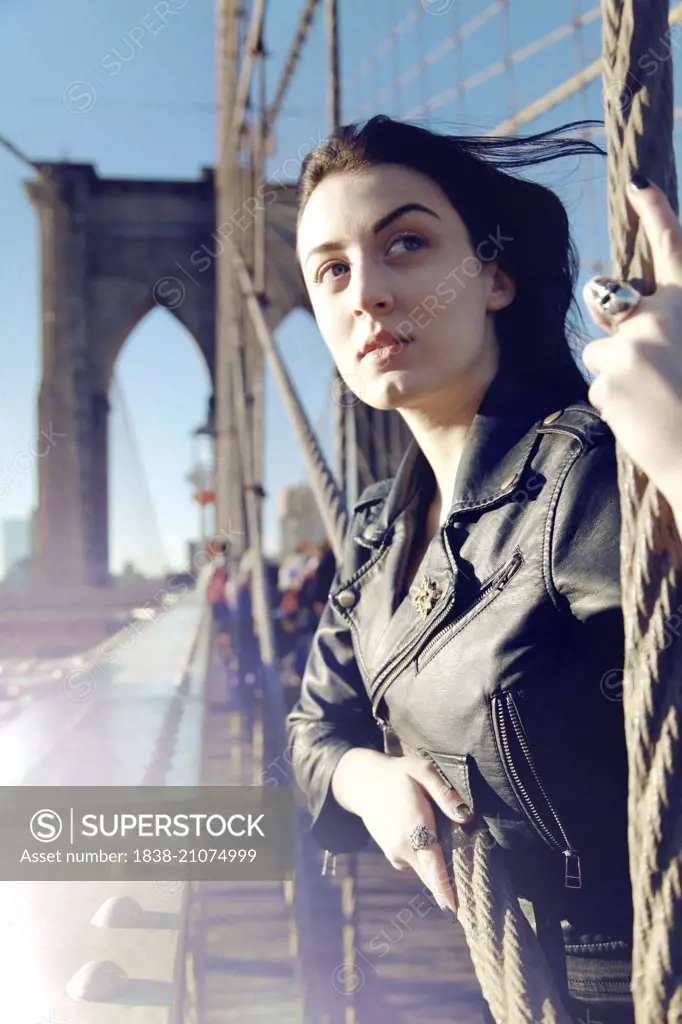 Young Adult Woman on Brooklyn Bridge Looking into Distance, New York City, New York, USA