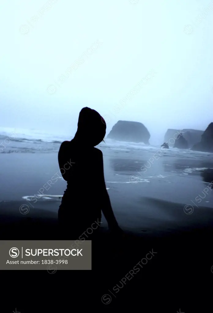 Silhouetted Girl on Misty Beach 