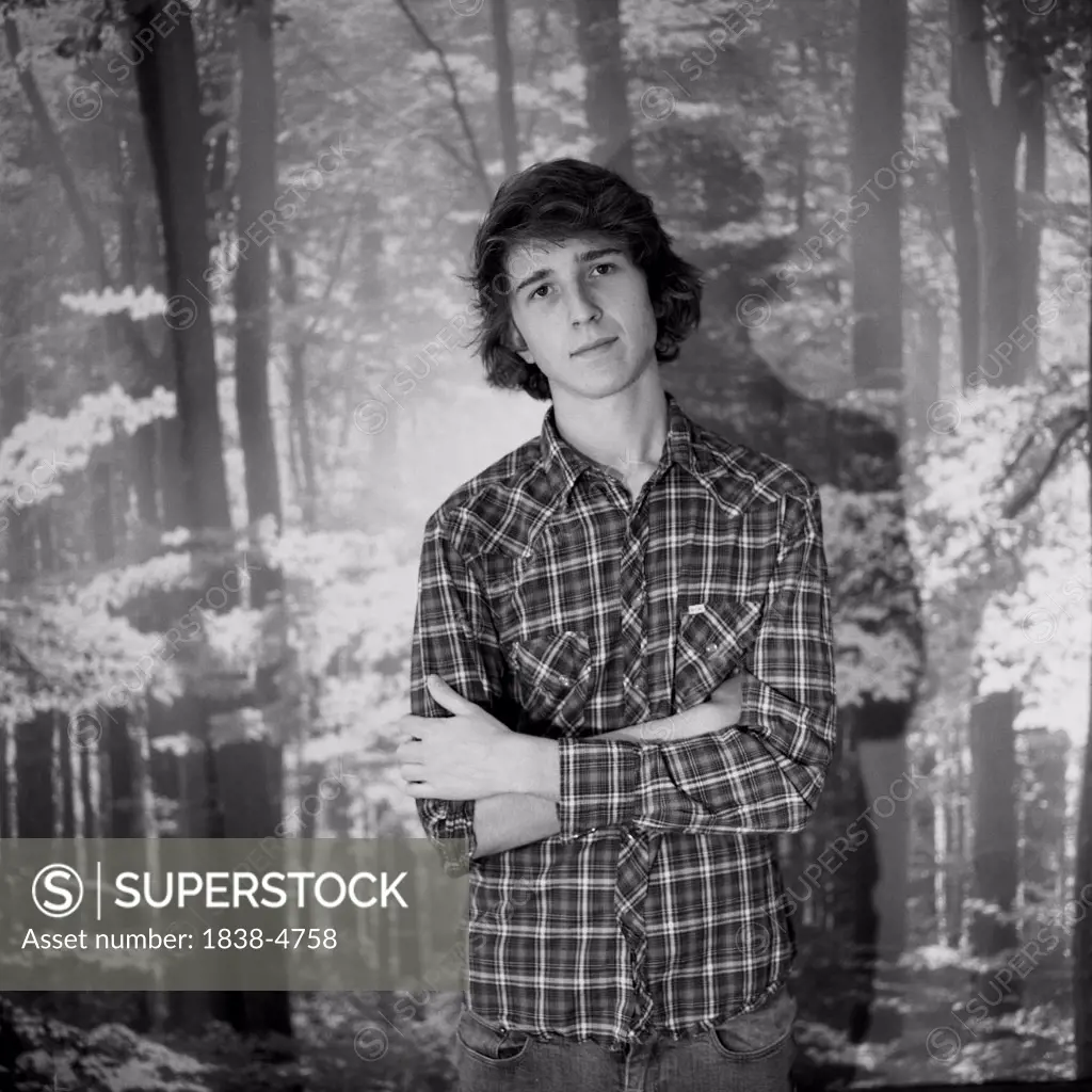 Young Man in Plaid Against Forest Backdrop