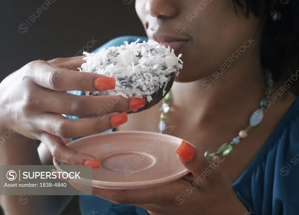 Woman Eating Coconut Doughnut