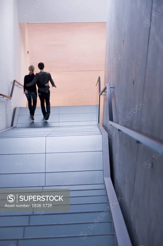 Two people walking down a stairway