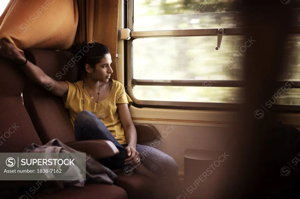 Young Reflective Woman sitting Inside Train