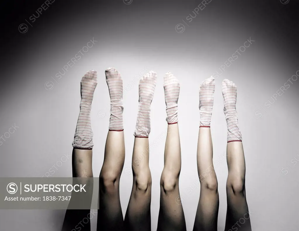Three Women Wearing Striped Socks and Legs Sticking Up in the Air
