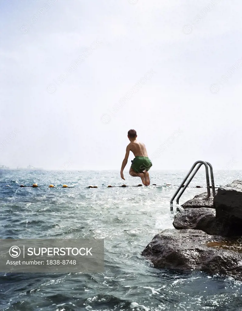 Boy Jumping into Ocean
