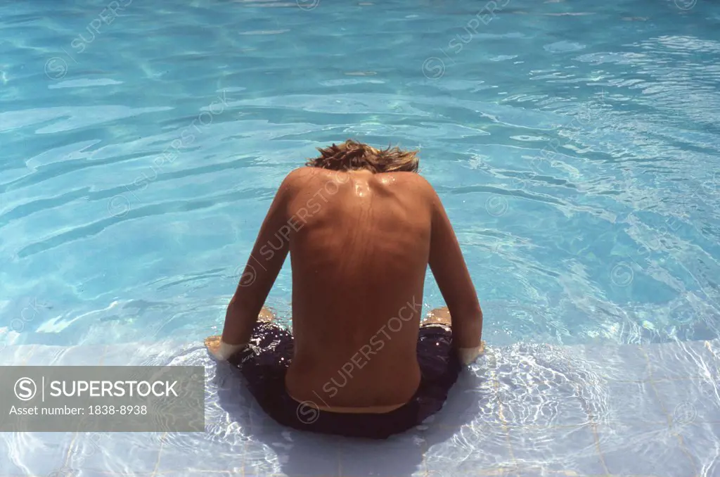 Boy Sitting by Side of Pool