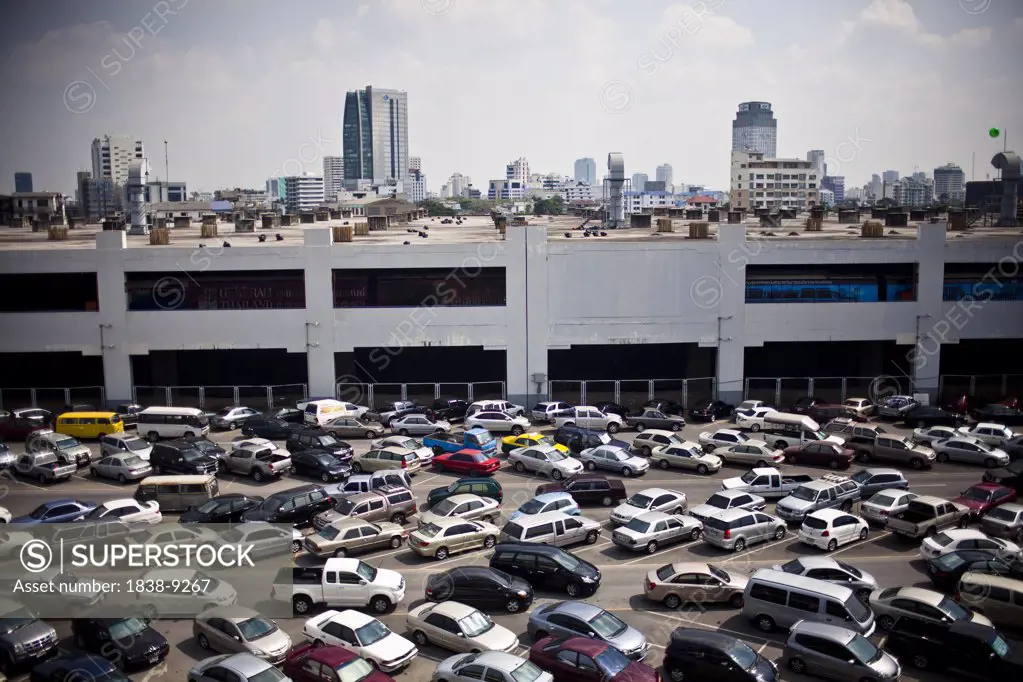 Parked Cars at Train Station With Skyline in Background, Bangkok, Thailand, Asia