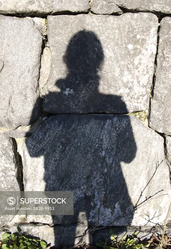 Human Shadow Against Rock Wall