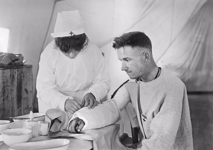 American Red Cross Nurse bandaging arm of Wounded American Soldier, American Military Hospital No. 5, a complete portable Tent Hospital supported by American Red Cross, Auteuil, France, Lewis Wickes Hine, American National Red Cross Photograph Collection, June 1918