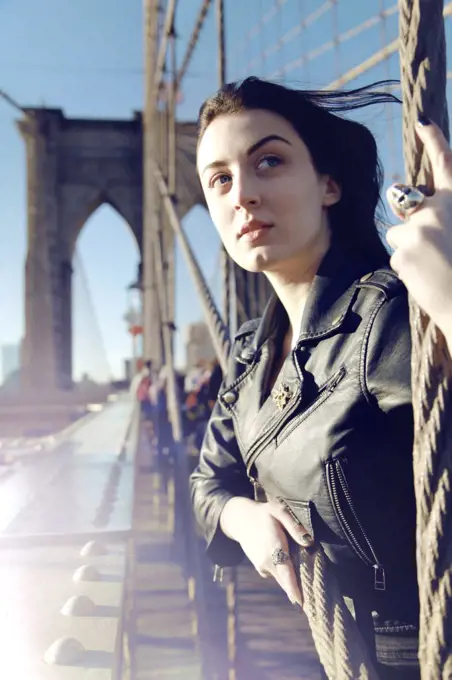 Young Adult Woman on Brooklyn Bridge Looking into Distance, New York City, New York, USA