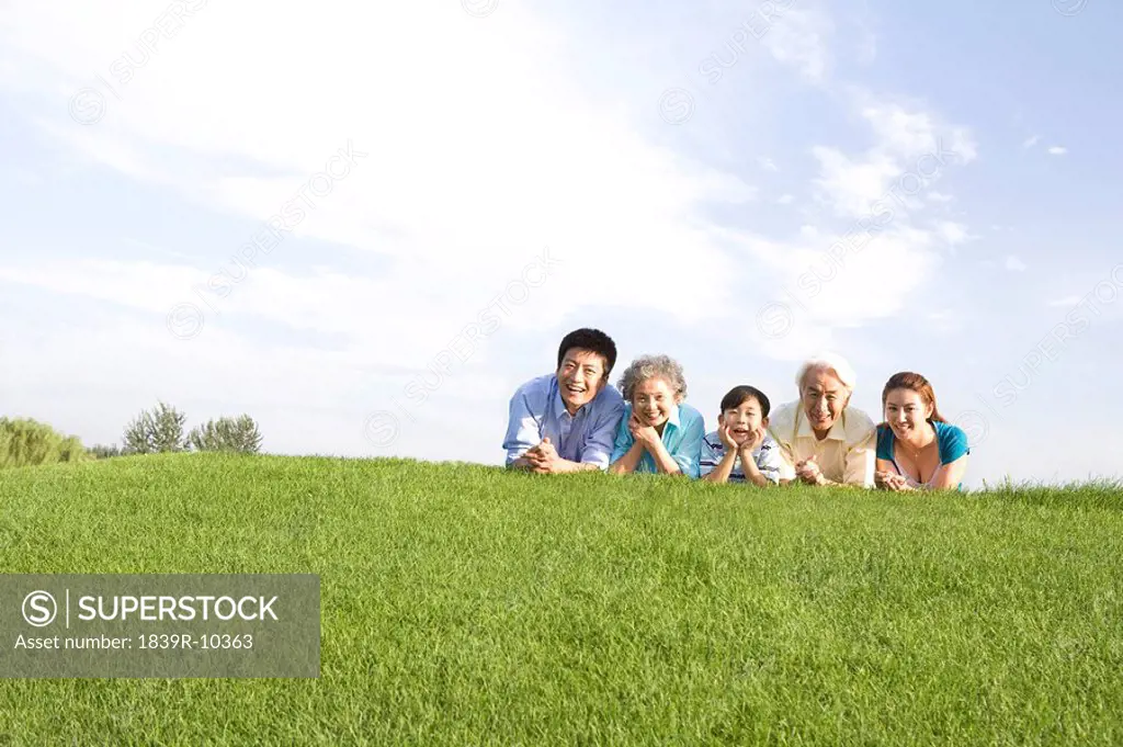 Three generation family lying on the grass