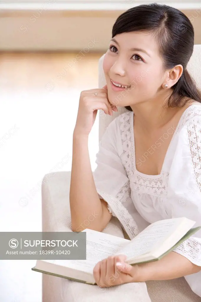 Asian woman reading on a sofa