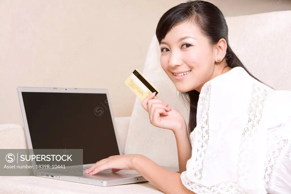 Asian woman with credit card and laptop