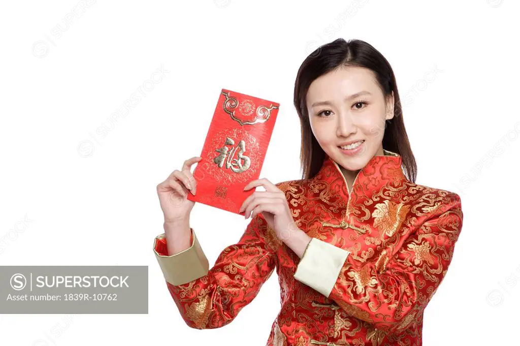 Young woman in Chinese traditional clothes holding red envelope
