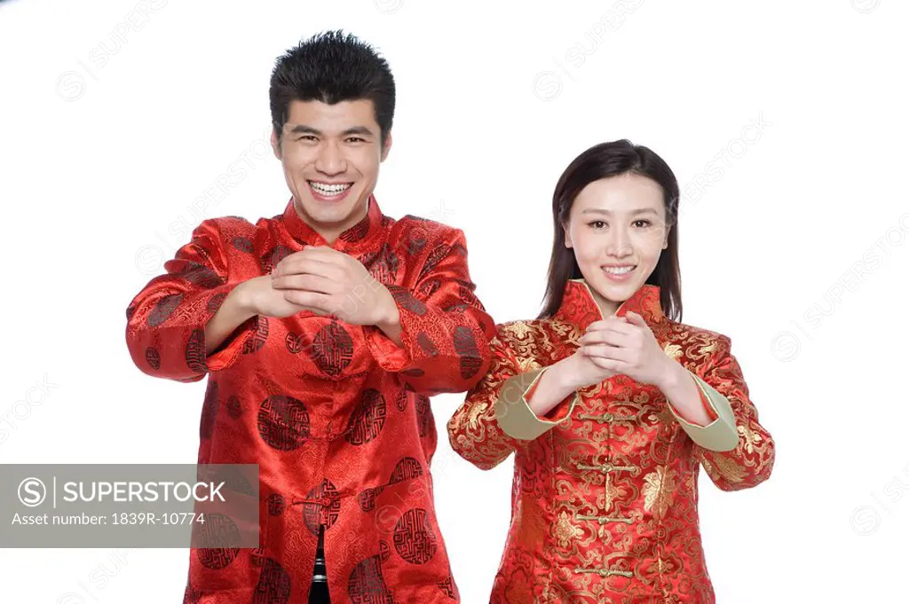 Young couple in Chinese traditional clothes giving best wishes