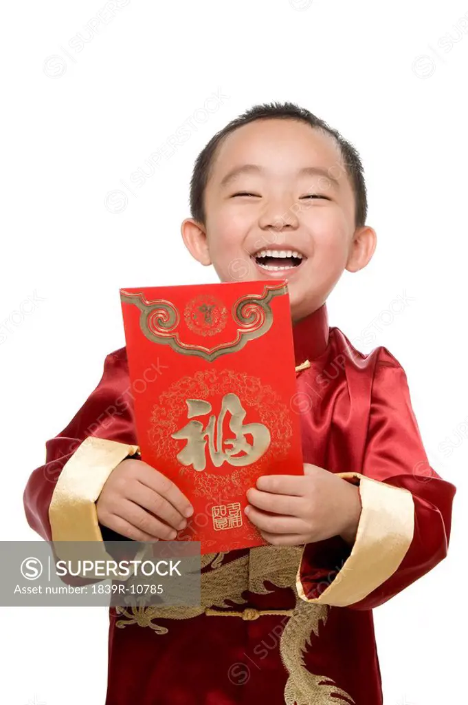 Boy in Chinese traditional clothes holding red envelope