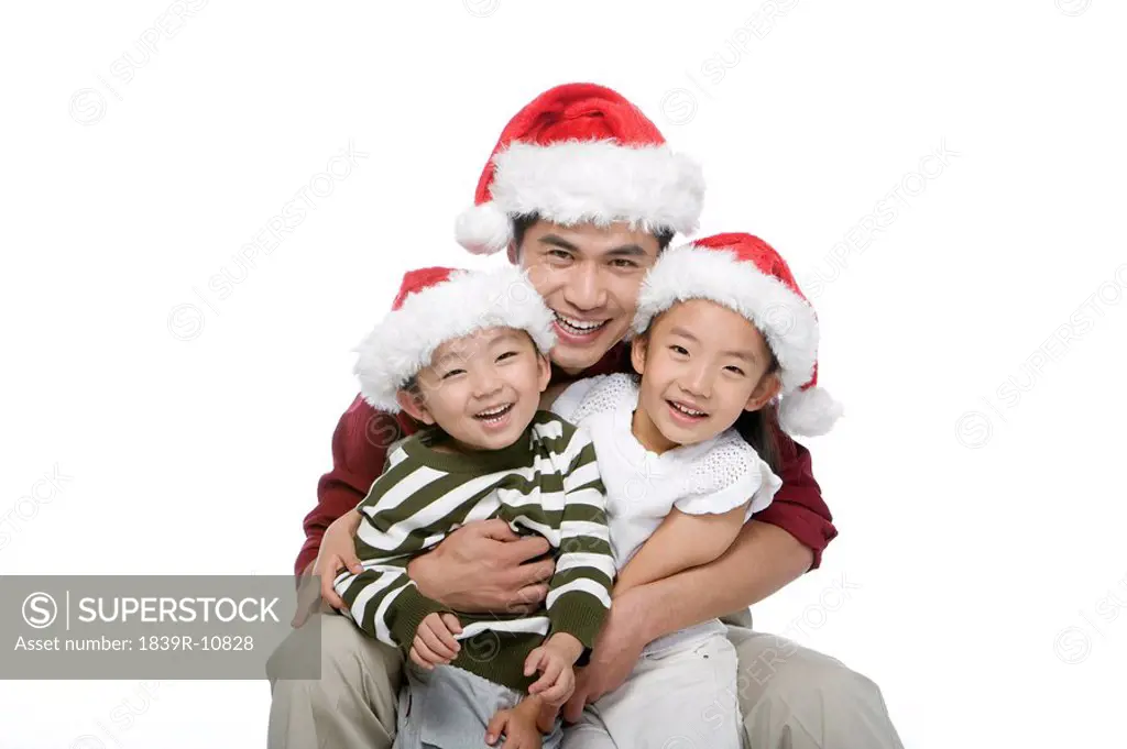 Father and children with Santa hats