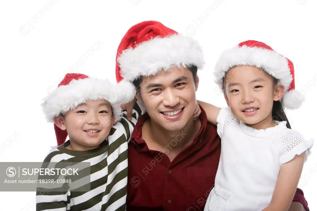 Father and children with Santa hats