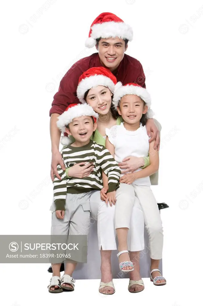 Portrait of family of four with Santa hats