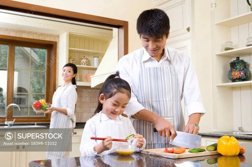 A family of three cooking in kitchen