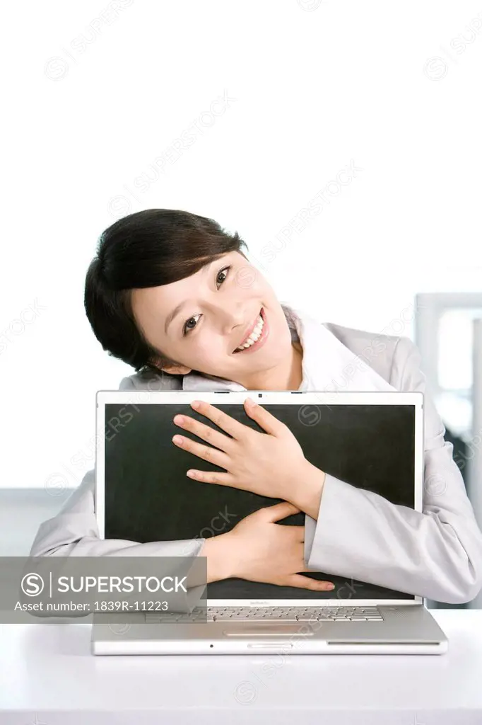Office worker hugging her computer