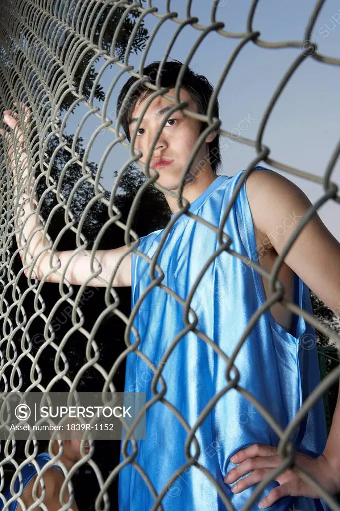 Young Man Standing In An Enclosed Basketball Court