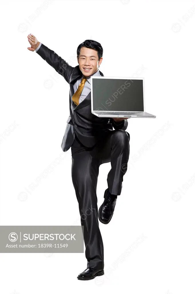 Businessman in fighting stance holding laptop