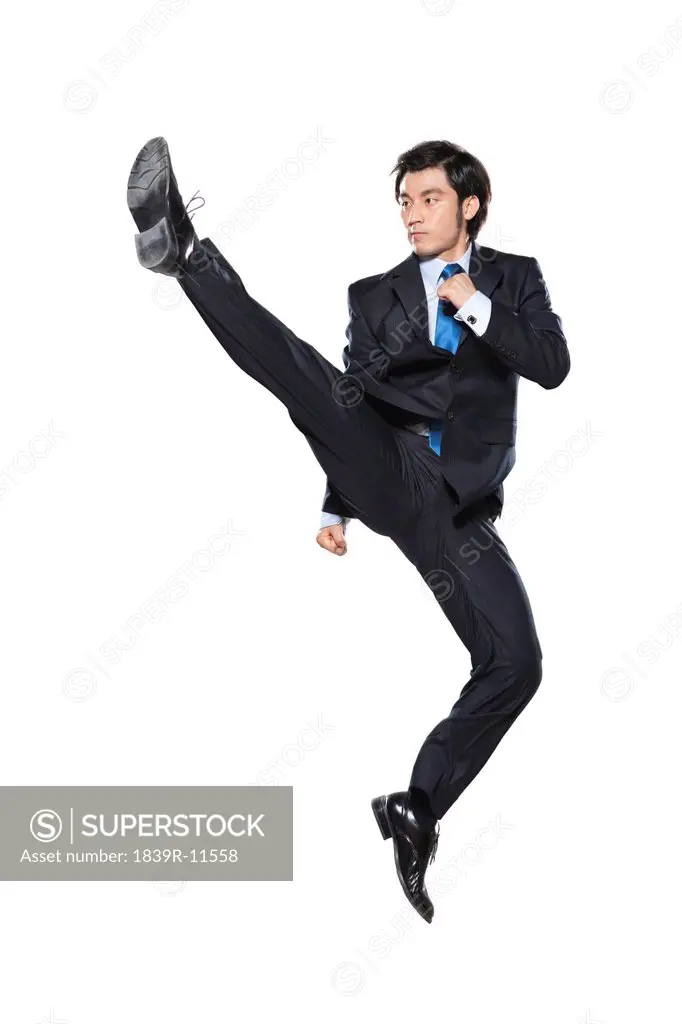 Businessman doing a karate kick