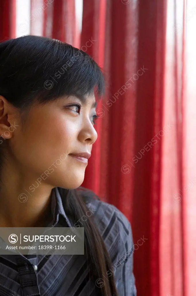 Woman Looking Out Of Window Contemplatively