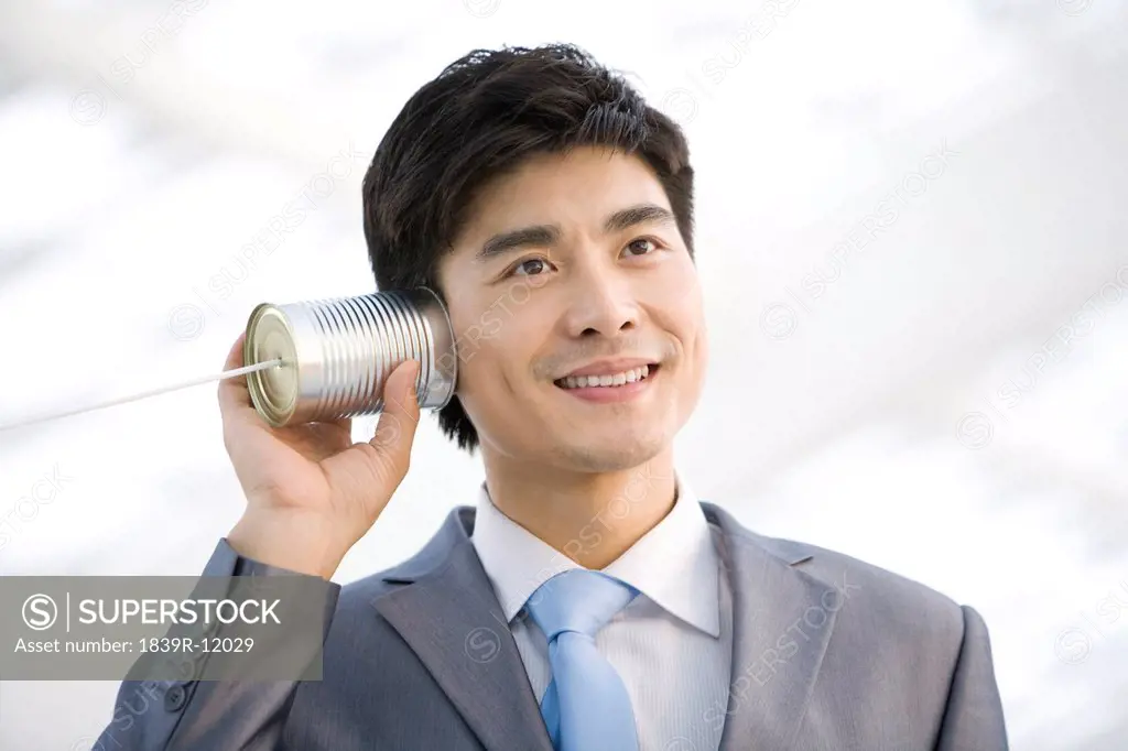Businessman using tin can phone