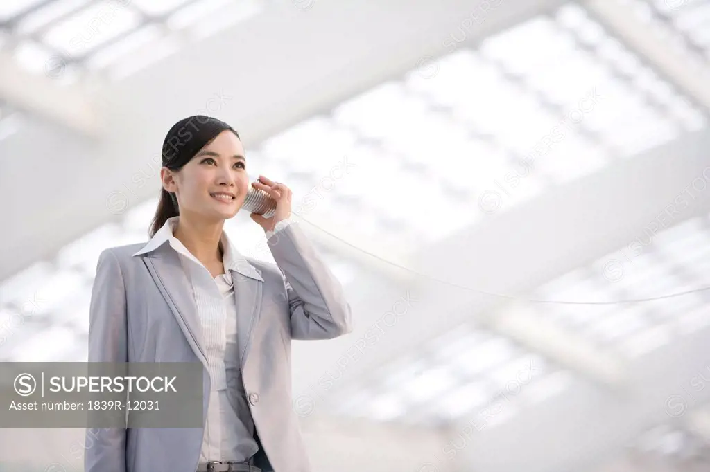 Businesswoman using tin can phone