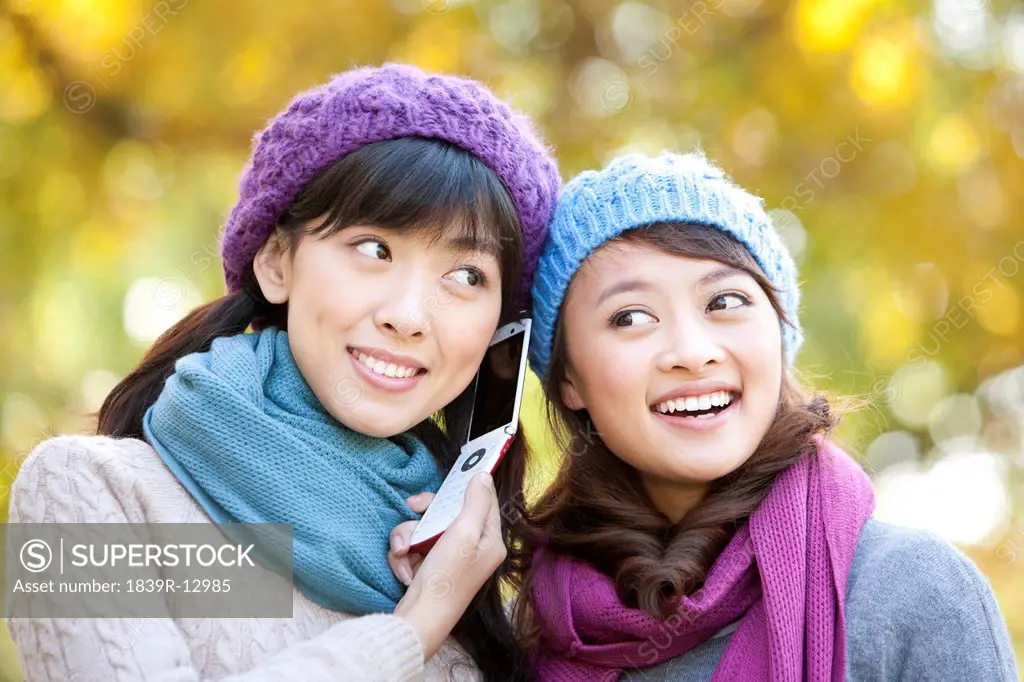 Two Young Women Listening to a Mobile Phone