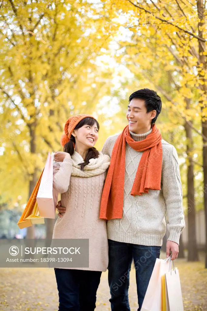 Young Couple in a Park with Shopping Bags