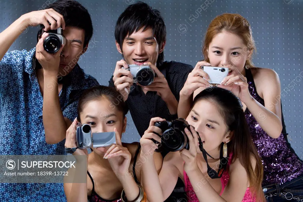 Young adults using digital cameras