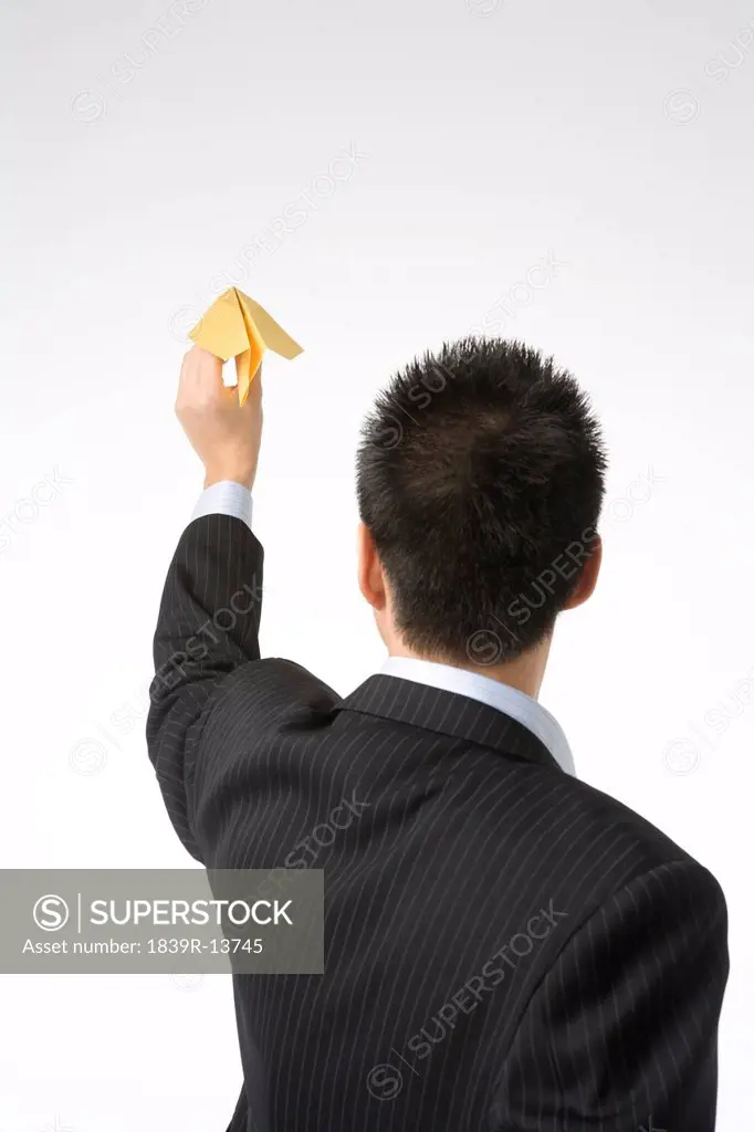 Businessman flying paper airplane