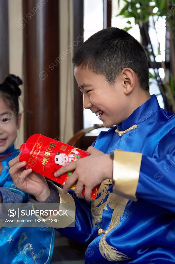 Boy and Girl Opening Chinese New Year Envelope