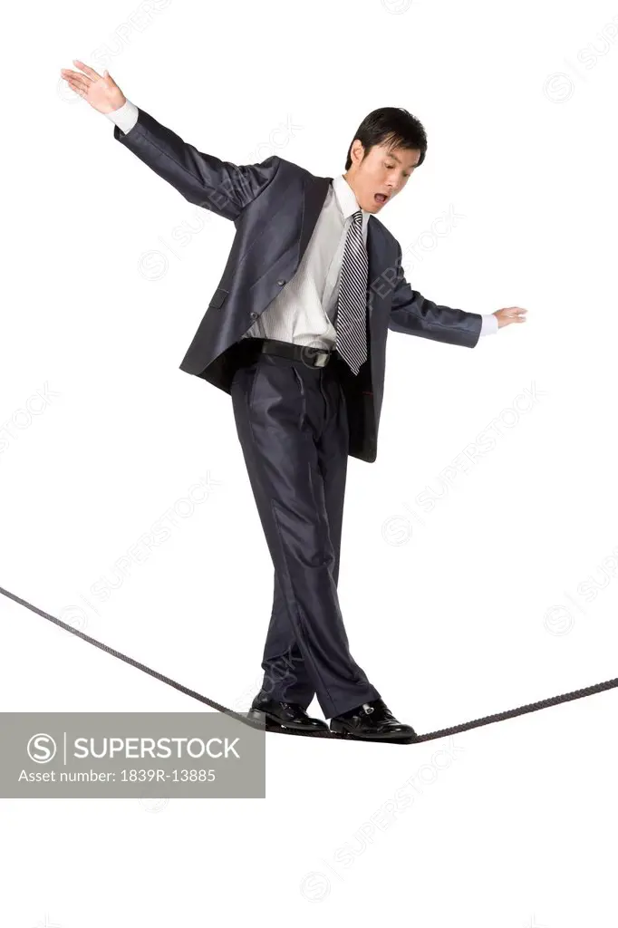 Businessman walking on rope in mid_air