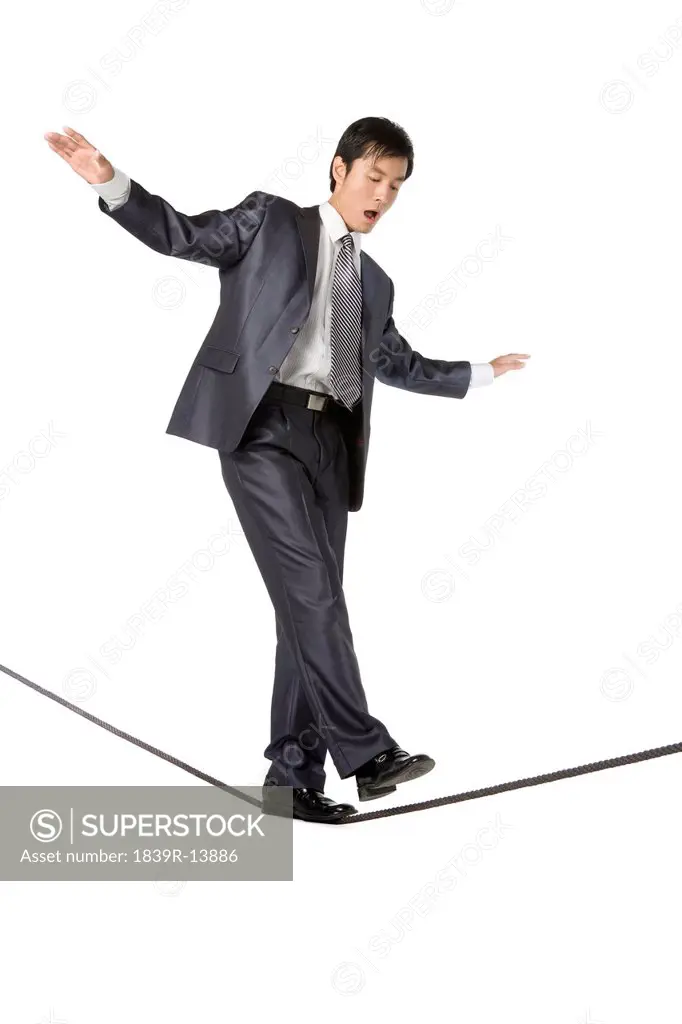 Businessman walking on rope in mid_air
