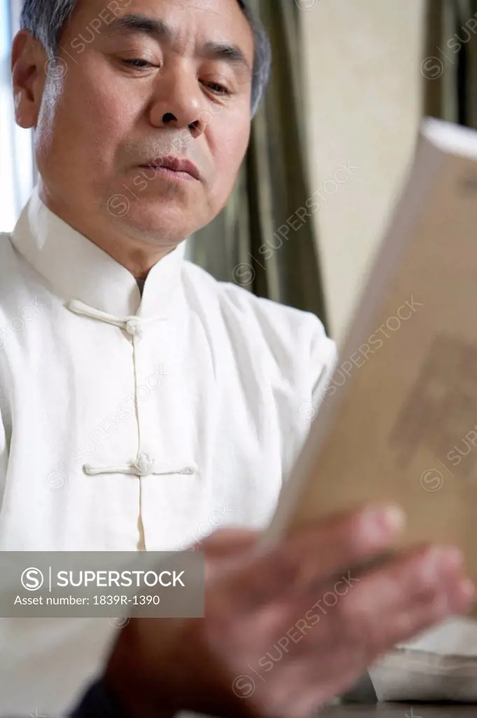 Man In Traditional Chinese Clothing Reading